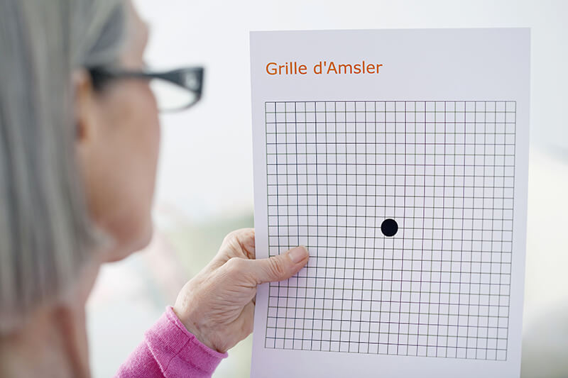 Woman using Amsler Grid to test for macular degeneration